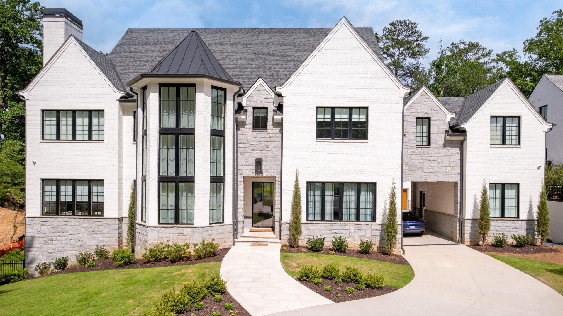 A large white house with a driveway in front of it.